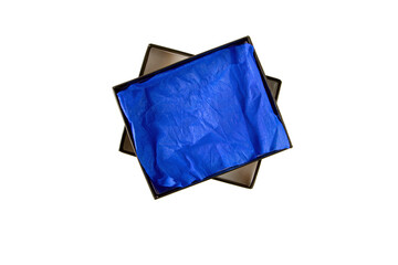 Opened black flat rectangular cardboard box with blue crumpled wrapping paper and tap.