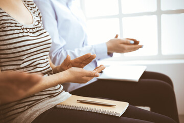 Business people clapping at meeting or conference, close-up of hands. Group of unknown businessmen and women in modern white office. Success teamwork, corporate coaching and applause concept