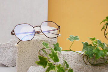 eye glasses on a concrete podium on a beige background, trend composition, stylish eye glasses on a...