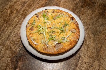 A delicious cooked Sausage and Hash Brown Frittata on a wooden kitchen table