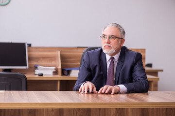 Old businessman employee sitting in the office