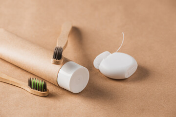 Close-up on set of two wooden toothbrushes, toothpaste and dental floss