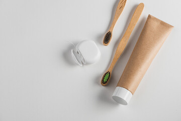 Top view on set of dental floss, bamboo toothbrushes and toothpaste