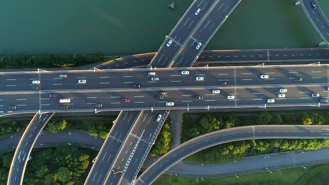 Aerial drone view of highway multi-level junction road with moving cars at sunset. Active movement of transport cars vehicles in different directions.The concept of the urban. China. Top down view.