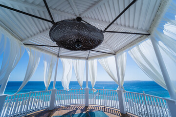 Romantic gazebo on the beach with blue sea