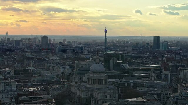Aerial wide shot of London Downtown with with structures and bt tower in background. Golden sky during sunset with cloudscape.