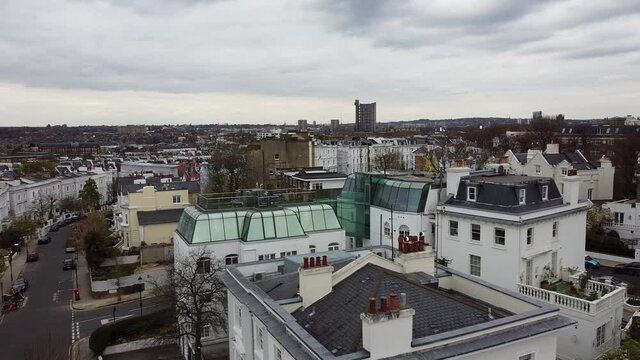 Aerial view of apartment blocks and mirrored windows on rooftop terrace in Notting Hill, London.