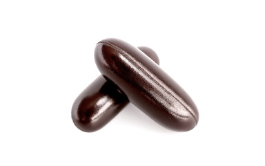 Dark brown supplement capsule isolated on white background