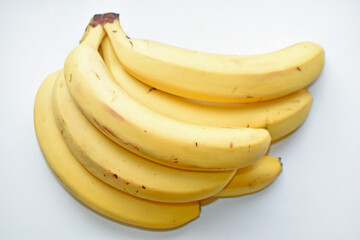 A bunch of yellow and ripe bananas on a white background