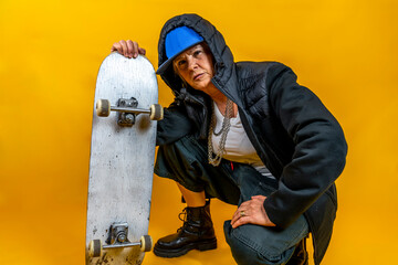 Funny portrait of mature woman. Lady having fun with skate dressed as rapper