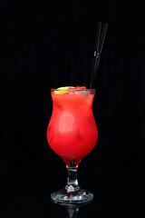 Red club cocktail with lemon and two straws on black background