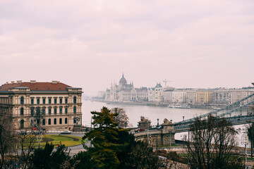 Great view of the parliament building, shrouded in haze, in daylight in Budapest