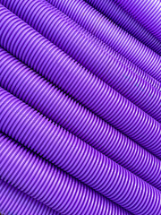 Pattern formed by purple corrugated plastic pipes used for communications cables. No people. Copy space.