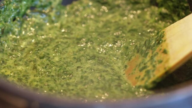 Boiling spinach in a pan with a spatula. [4K]