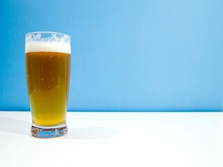 Bière blonde sur fond bleu