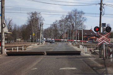 Fototapeta na wymiar There are cars at the railway crossing. The barrier is lowered the red signal of the semaphore is lit Russia, Moscow April 2021