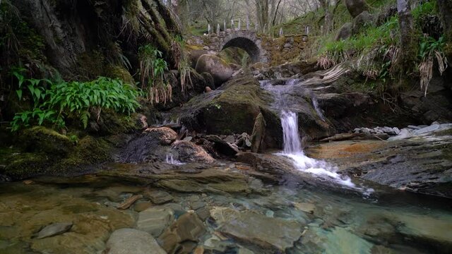 4k real time footage of stream and rock pool below the famous Fairy Bridge at Glen Creran, Argyll and Bute, Scottish Highlands. Bridge in background. Idyllic and peaceful with audio of running water.
