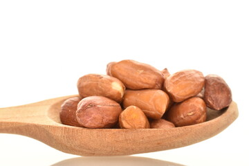 Obraz premium Organic peeled peanuts with a wooden spoon, close-up, isolated on white.