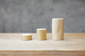 Thin and short barkless wooden log blocks on wooden table. Barkless cedar log set lined up individually in order of height on wooden background. 