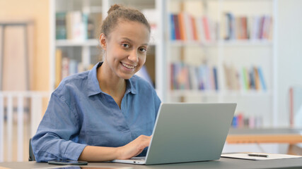 Cheerful African Woman with Laptop Smiling at Camera