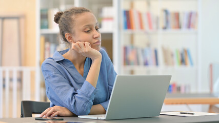 Pensive African Woman Sitting and Thinking in Library