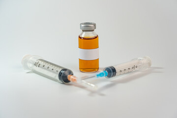 Studio shot of vaccine bottle with blank label and syringes 