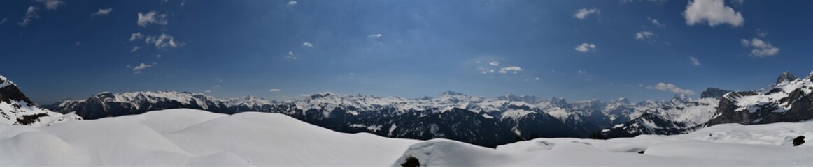 Fototapeta premium Panorama of snow-capped Swiss mountains in the canton of Glarus with the Tödi mountain in good weather and blue skies 