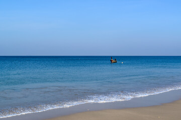 Obraz premium A Thai traditional long-tailed boat anchors on the shore of Phra Ae Beach (Long Beach), Koh Lanta, Krabi, Thailand.
