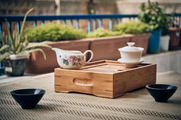 Hands of man brewing puerh tea. Man pours tea from gaiwan to bowl at tea tray. Chinese traditional gongfu cha tea ceremony.