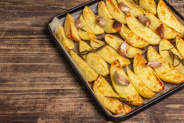 Baked pieces of spiced potato in a baking pan