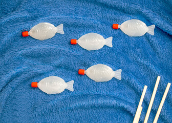 Photo on the subject Zero waste and recycling. Plastic fish container from soy sauce from sushi sets on blue background. Environmental problem and disposable items. World ocean pollution. 