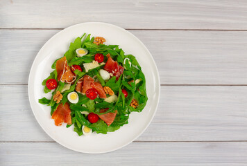 Salad, arugula leaves, with Parma prosciutto, cherry, quail eggs, healthy food, top view, horizontal, no people,