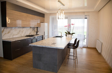 Modern and sunny kitchen with a marble kitchen island in the middle. Design, interiors.