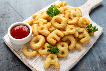 Letters potato fries snack with ketchup on white board. party food