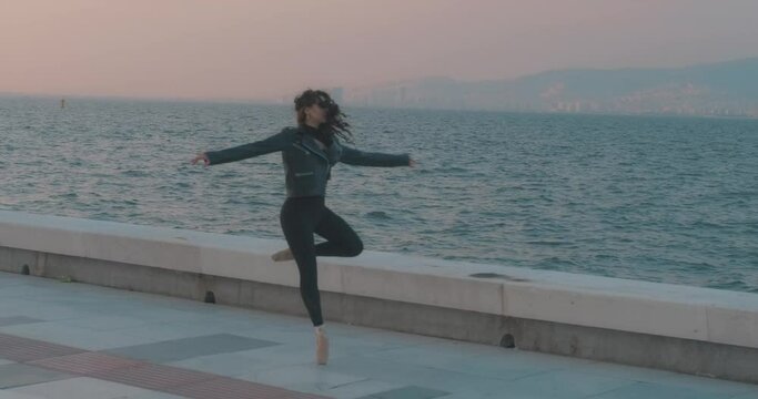 Beauty woman is dancing sunset time, seaside. Professional ballet dancer, choreography. Dancing, jumping and stretching. Flexible sportive woman's harmony.