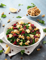 Kale salad with apple, beetroot, walnut and raisins in white plate. Healthy food
