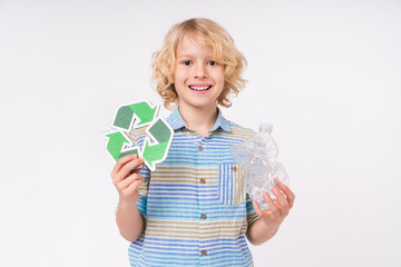 Eco-friendly caucasian school boy holding plastic bottle for recycling isolated on white background