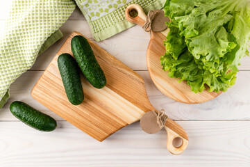 Variety of green vegetables copyspace with cutting board on white