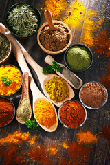 Variety of spices on wooden kitchen table.