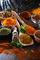 Variety of spices on wooden kitchen table.