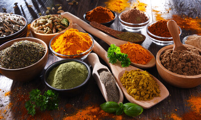 Variety of spices on wooden kitchen table.