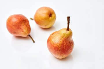 three ripe red pears on a white background