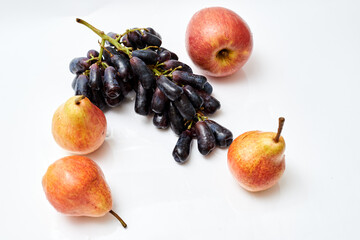 a bunch of grapes with apples and pears on a white background