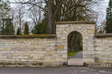 Hewn stone fence with arched entrance.Ф