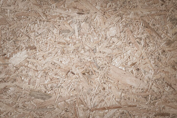 Chipboard, OSB -Oriented strand board particle pressed recycled wood panel background with grainy wooden fiber pattern backdrop in natural beige brown color