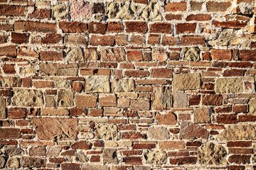 Ancient wall of red stone. Abstract natural background.