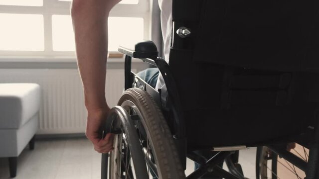 Cropped image of disabled man using wheelchair at home