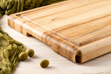 Empty wooden cutting board with olives with copy space