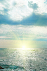 Fototapeta na wymiar Seascape with sun and clouds on sunset sky