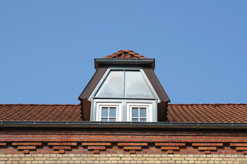 Attic windows on the tiled roof of a residential building.